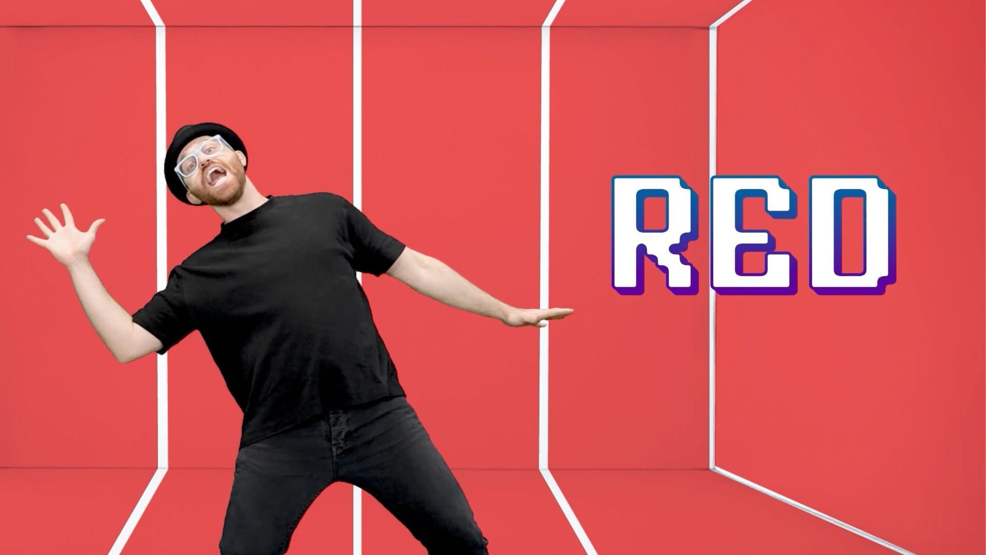 DJ Raphi in his black hat, glasses, and all-black outfit leaning back with arms outstretched against a red wall, next to the word "RED"